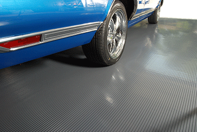 Ribbed texture garage flooring mat in slate grey shown with a rear right side of a classic vehicle on the mat