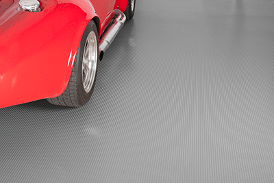 Ribbed Channel texture mat in slate grey show with the lower side of a sports car on the mat