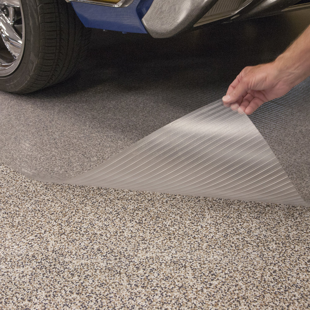 Hand lifting edge of clear vinyl floor mat