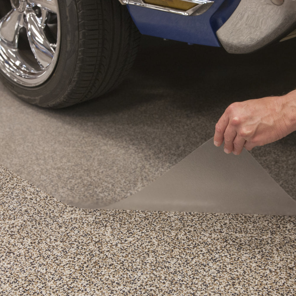Hand lifting edge of clear vinyl floor mat