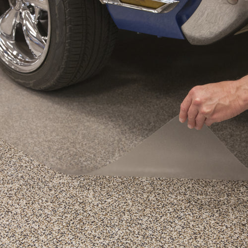 Hand lifting edge of clear vinyl floor mat