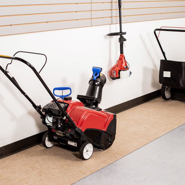 Red and black snowblower on top of Tan Drip & Dry Runner