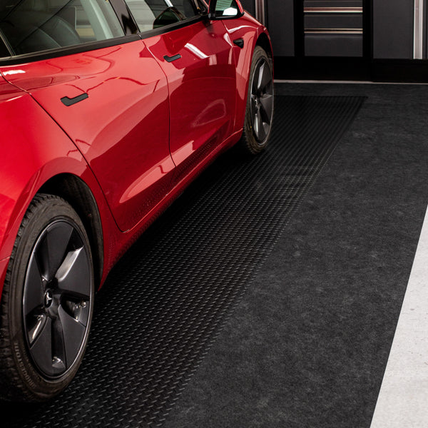 Red car parked on Midnight Black Diamond Tread vinyl flooring with Grey Drip & Dry runner