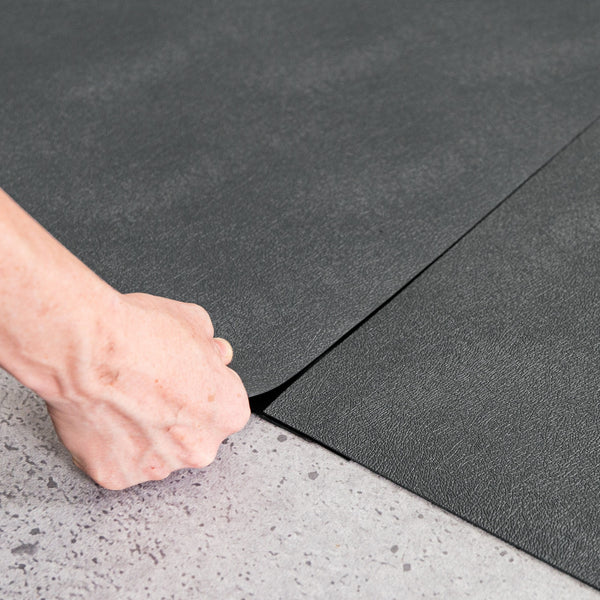 Hand lifting Slate Grey Levant texture vinyl flooring and black seam tape