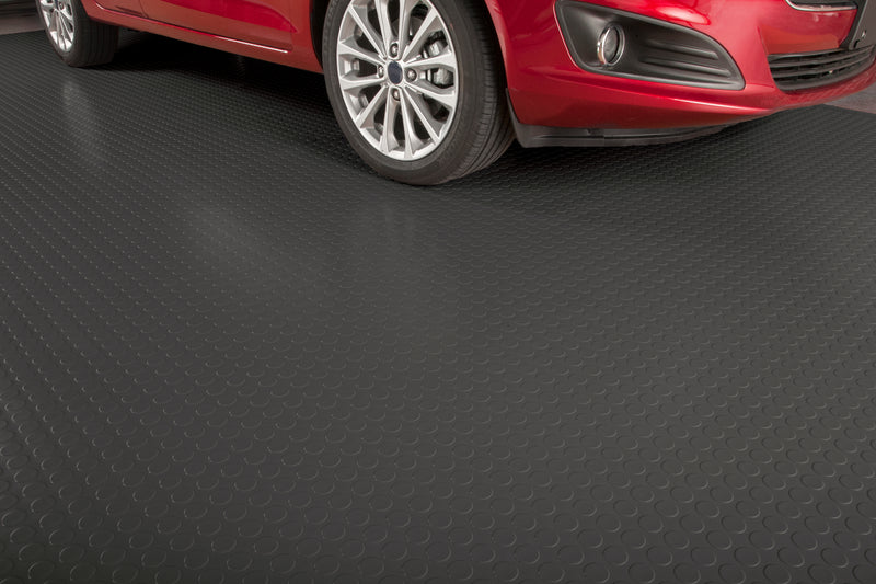 Large Coin in slate grey shown with a partial vehicle on the mat as an example of garage flooring