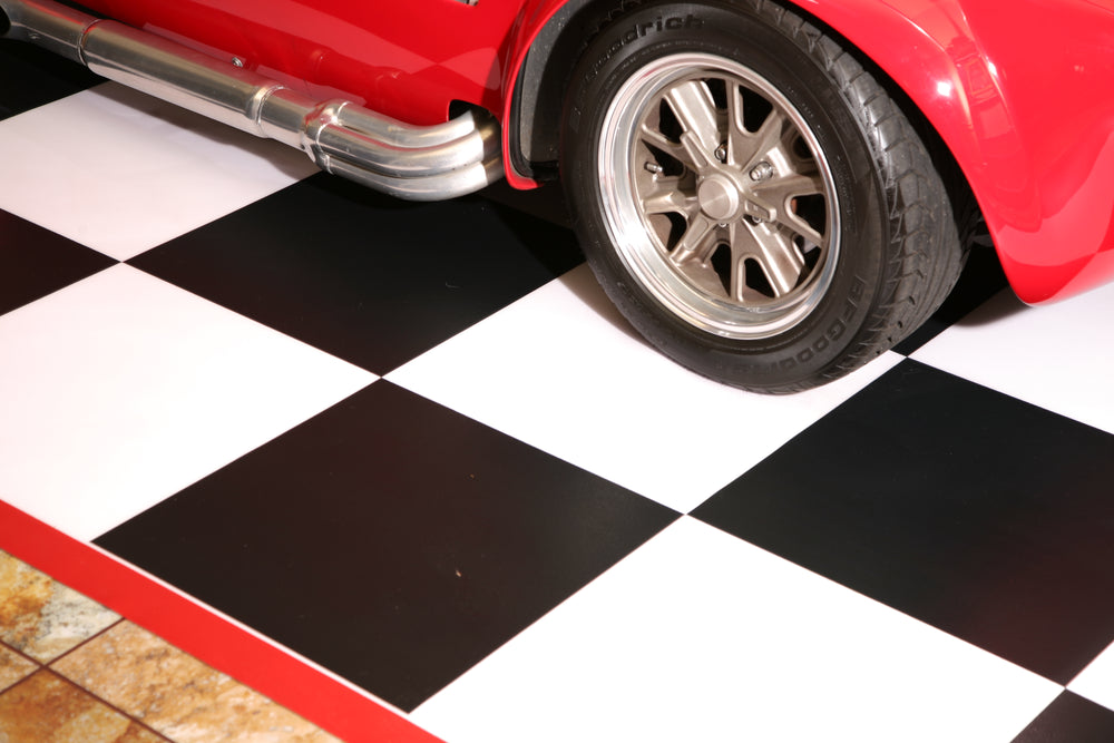 Red car on checkerboard imaged parking pad with red border