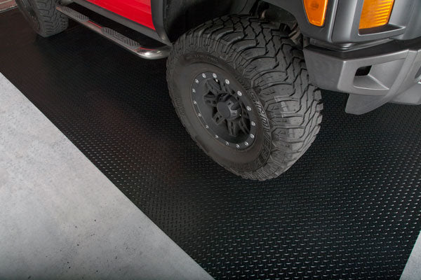 Diamond Tread texture garage floor mat in midnight black partial view shown with a 4WD truck on the mat