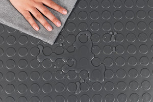 Hand wiping water puddle on Slate Grey large Coin texture vinyl flooring