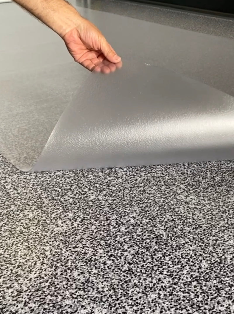 Hand lifting corner of Clear Ceramic texture vinyl golf cart mat